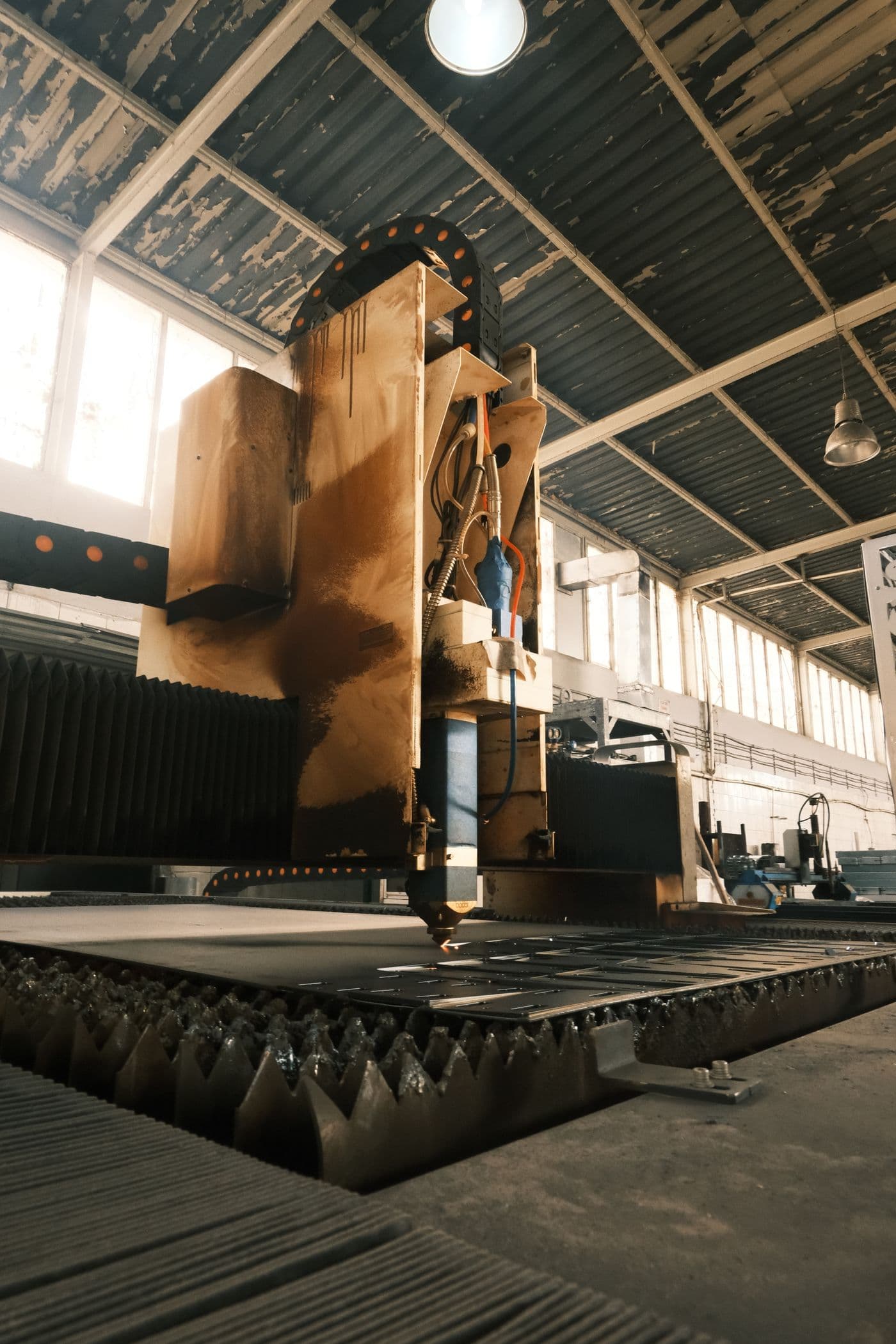 Industrial laser-cutting machine fabricating precision metal parts in a modern factory
